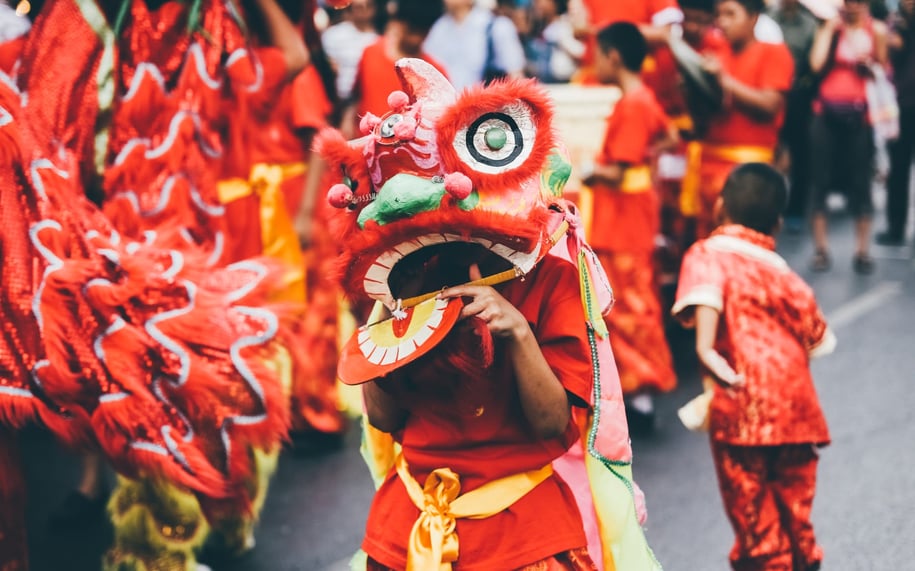 A person is dressed in a dragon outfit for Chinese New year street celebrations. 